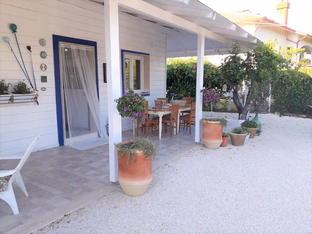 Il patio con tavolo, sedie e piante in vaso de Gli oleandri