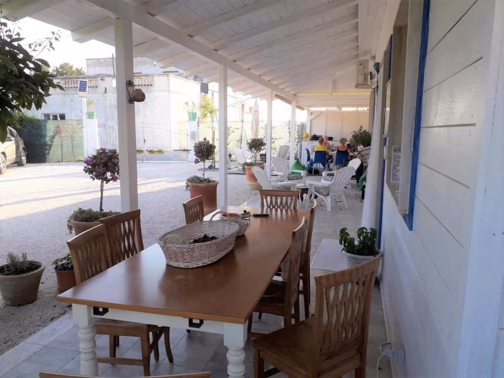 Tavolo e sedie in legno sul patio della struttura